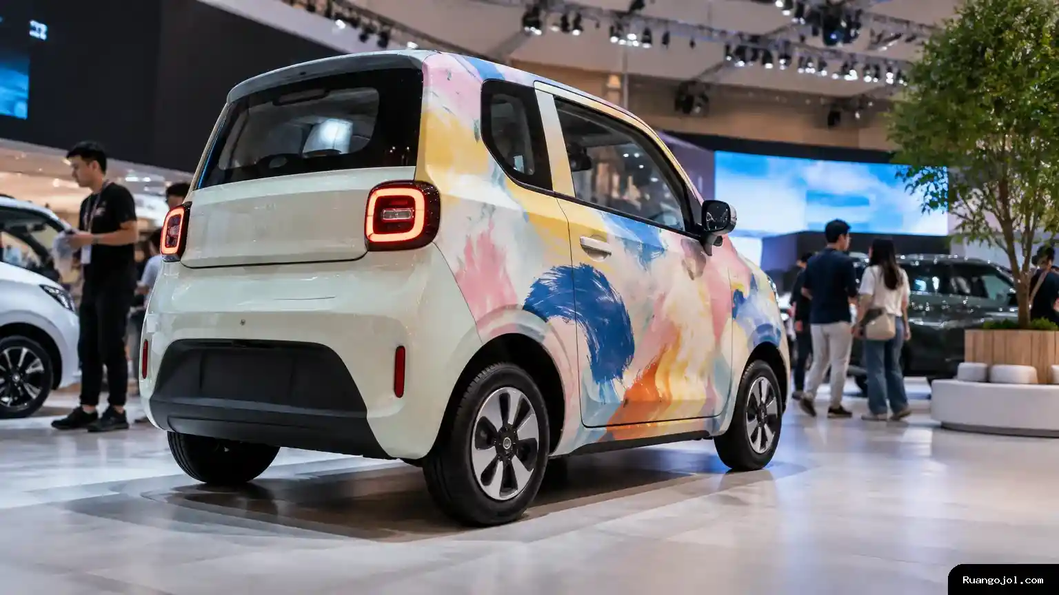 Sebuah mobil listrik dengan lukisan pada bodi dipamerkan di dalam gedung pameran otomotif, menggambarkan kolaborasi seni dan modifikasi yang ditampilkan pada IMX 2026. Wuling Air ev dengan lukisan di area pameran