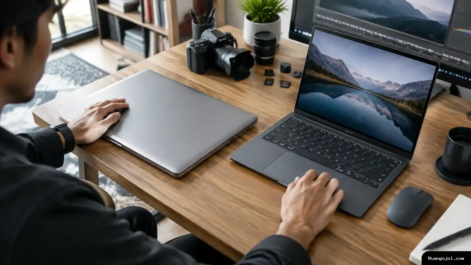 MacBook Pro dan laptop Windows di meja kerja