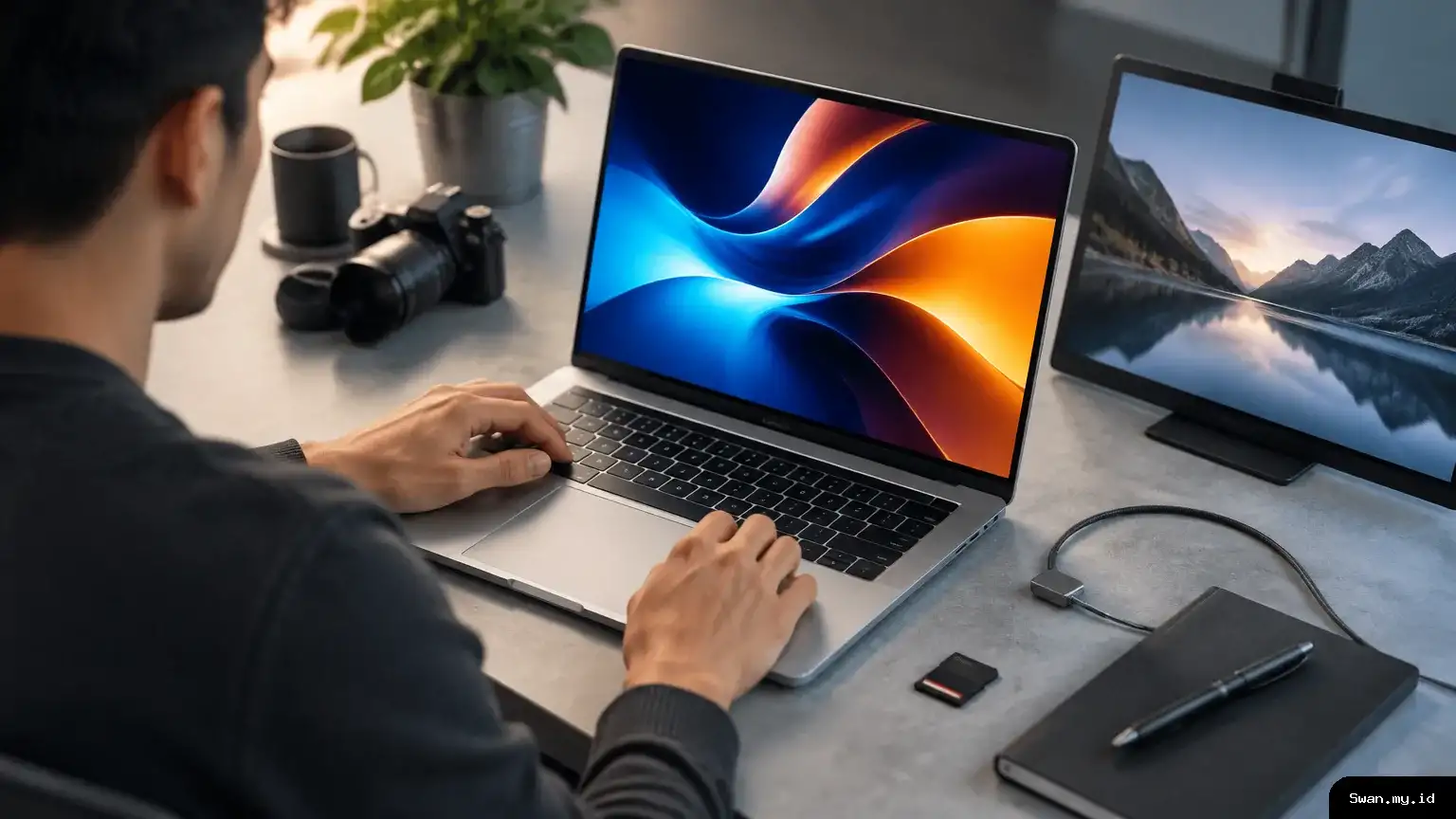 A premium laptop sits open on a creative workstation, with its display, touchpad, ports and magnetic charging cable visible. Premium aluminum laptop on a creative workstation